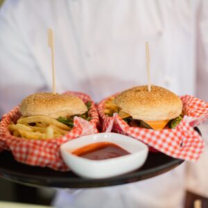 Close up of chef holding burgers in plate