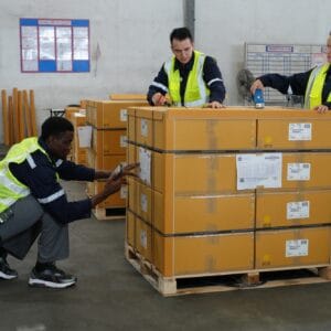 Warehouse workers working in the large logistic distribution warehouse. Workers in reflective cloth