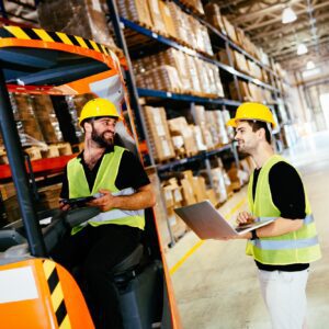 Warehouse workers working together with forklift loader